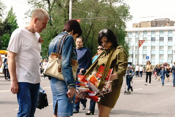 Rostov-on-Don / Rusia - 9 de mayo de 2018: Los vendedores ambulantes en las mesas en medio de la calle venden recuerdos, banderas rojas, cintas de San Jorge y simbolismo militar en honor a la fiesta del Día de la Victoria — Foto de Stock