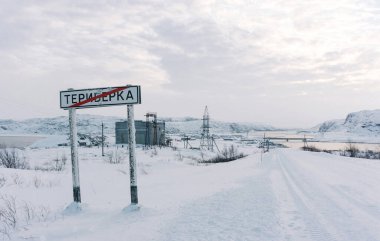 Teriberka, Murmansk bölgesi / Rusya - Şubat 2018: Turistlerin çeşitli çıkartmalarıyla süslenmiş beyaz kar altında Teriberka köyüne girildiği uyarısında bulundu