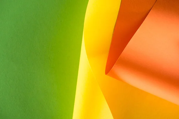 Detailní Záběr Válcované Žluté Oranžové Papírů Zeleném Pozadí — Stock fotografie