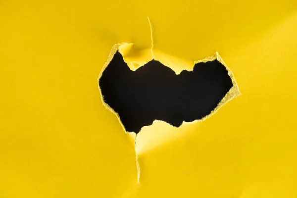 Close Tiro Buraco Papel Amarelo Isolado Preto — Fotografia de Stock