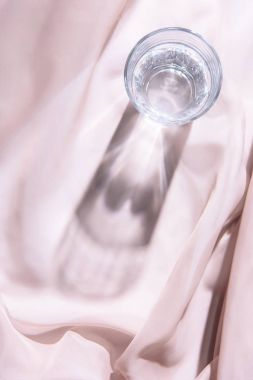 cam su ile üstten görünüm üzerinde pembe masa örtüsü  