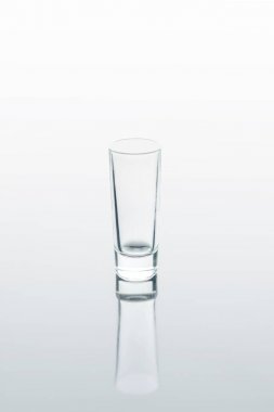 one small glass on white reflecting surface clipart