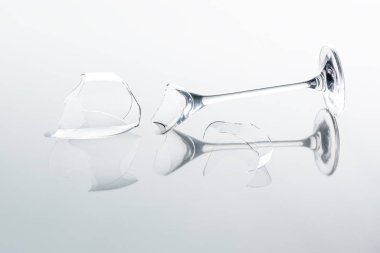 broken wineglass on white reflecting tabletop clipart