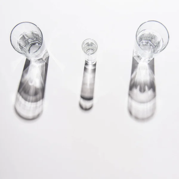 Hochwinkelaufnahme Von Verschieden Großen Gläsern Mit Wasser Auf Weißem Tisch — Stockfoto