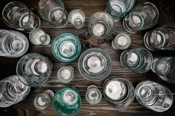 Κάτοψη Του Διαφορετικά Μεγέθους Γυαλιά Νερού Στο Ξύλινο Τραπέζι — Φωτογραφία Αρχείου