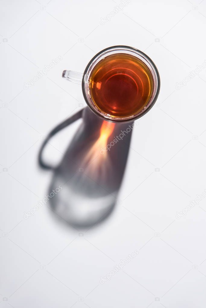 top view of glass cup with black tea on white table