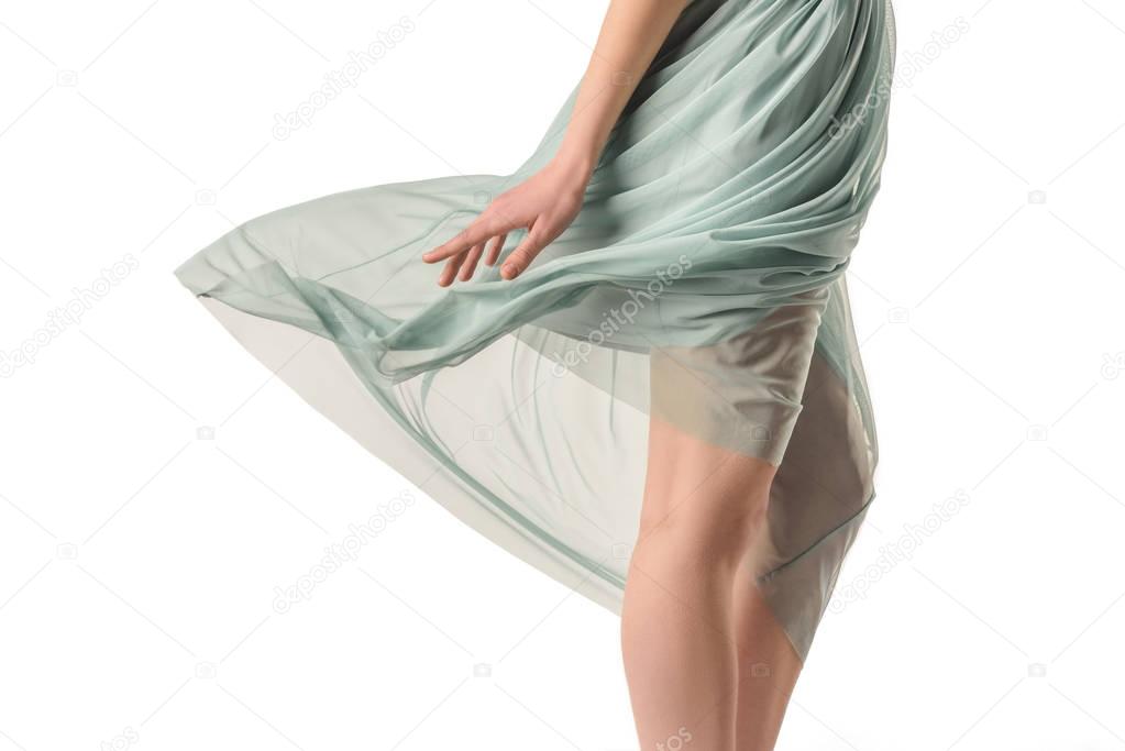 cropped view of elegant girl in transparent waving blue skirt, isolated on white