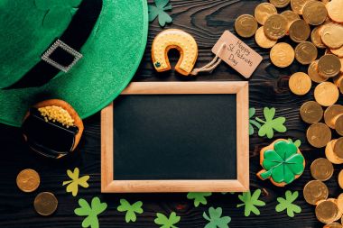 top view of empty board with gingerbread and shamrock on table, st patricks day concept clipart
