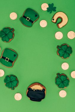 top view of icing cookies and golden coins isolated on green, st patricks day concept clipart