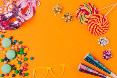 flat lay with candies and and party objects isolated on orange, purim holiday concept clipart