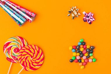düz lay tatlılar, lolipop ve portakal, purim tatil kavramı izole parti nesneleri ile