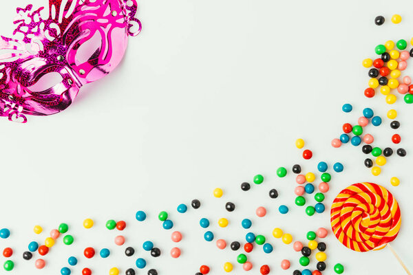 Плоский лежал с маской-маскарадом, лепестками и сладостями, изолированными на белом
