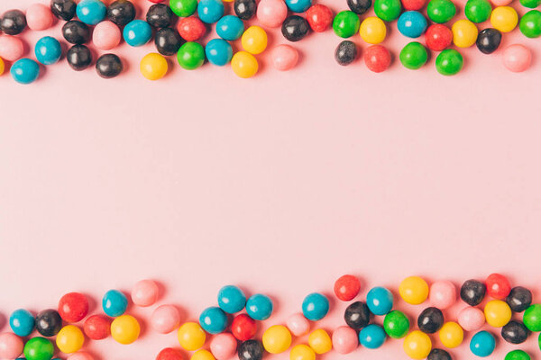 top view of arranged candies isolated on pink