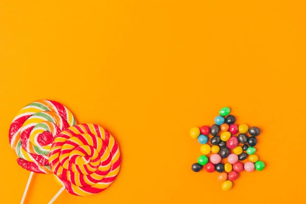キャンディー オレンジ プリムの休日の概念に分離されて成っているロリポップとスターのトップ ビュー — ストック写真