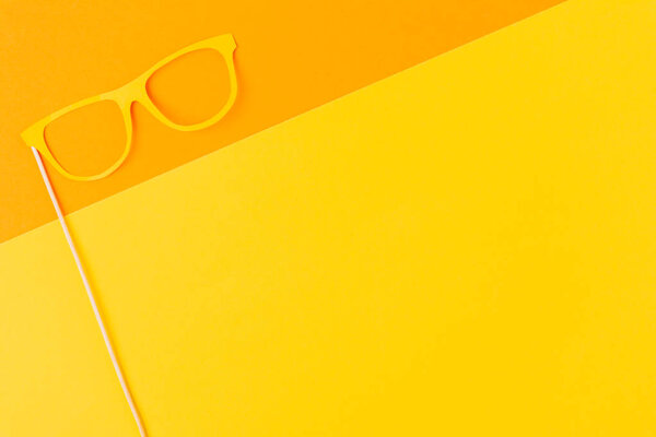 top view of masquerade mask on yellow and orange background