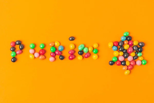 キャンディーのプリムのレタリングとオレンジで分離されたスターのトップ ビュー — ストック写真
