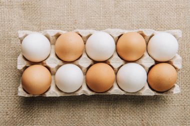 Beyaz ve kahverengi yumurta yumurta kartonu üzerinde çul döşeme