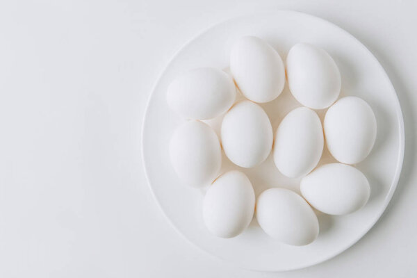 white eggs laying on white plate on white background