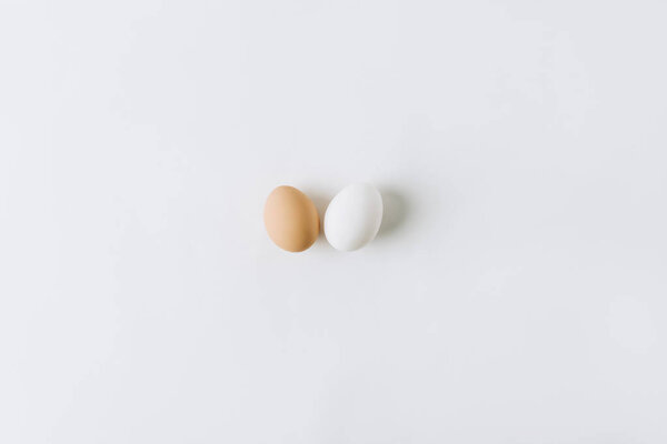 white and brown eggs laying on white background