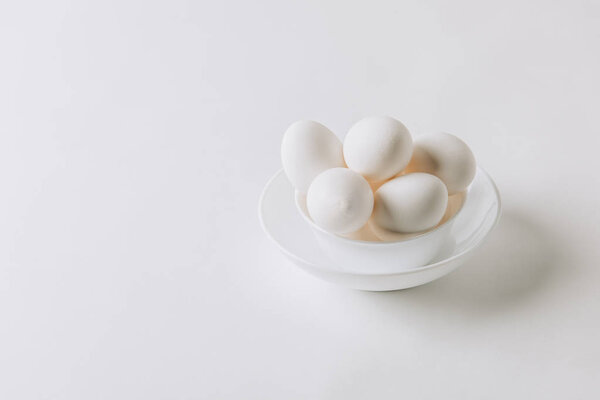 white eggs laying on white plate on white background 