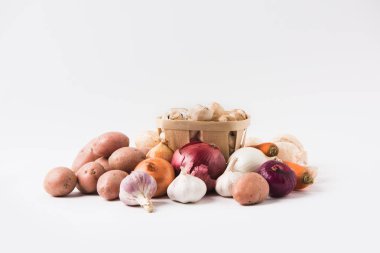 heap of mushrooms laying in basket over vegetables on white background   clipart