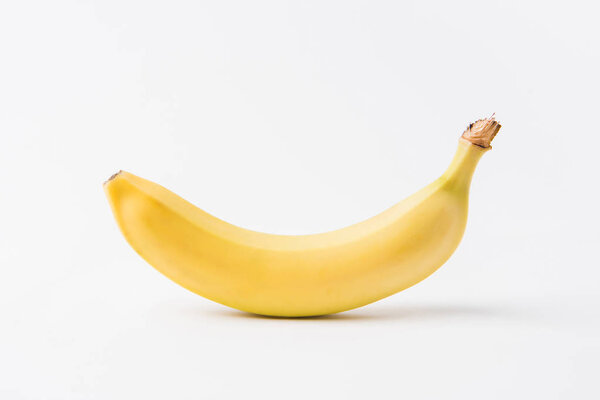 raw unpeeled banana laying on white background  