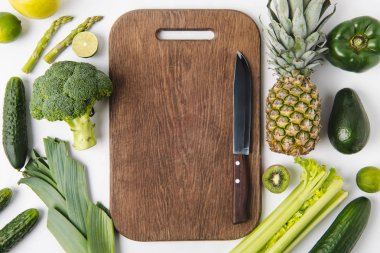 Ahşap kesme tahtası beyaz arka plan üzerinde izole meyve ve yeşil sebze ile bıçak