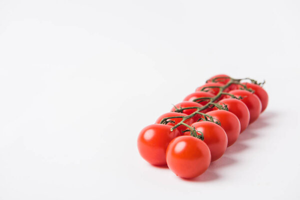 raw cherry tomatoes laying on white background