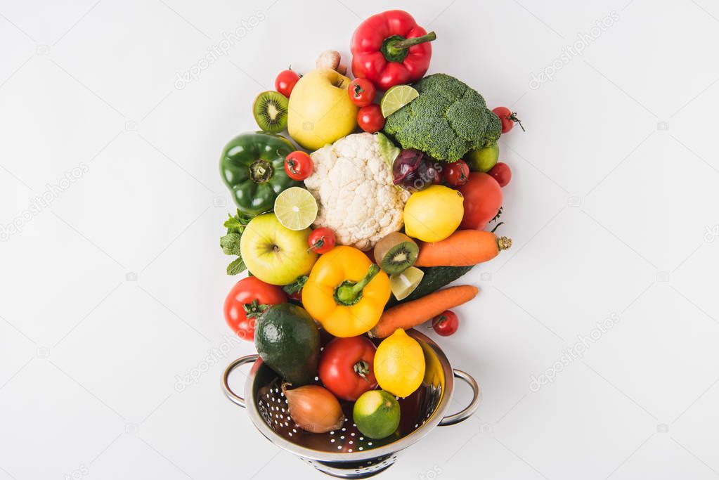 Eating healthy concept with vegetables and fruits in colander isolated on white background