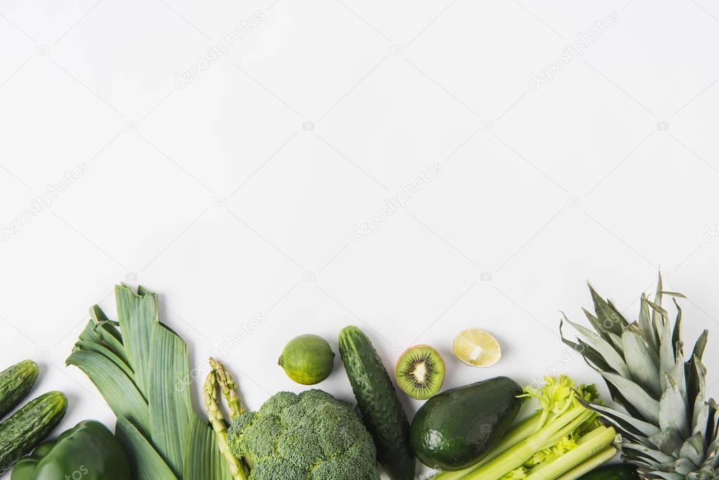 Border of green vegetables and fruits isolated on white background