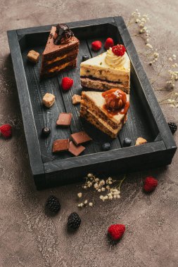 çikolata ve çilek ile lezzetli kek parçaları ahşap tepsi üzerinde görmek  