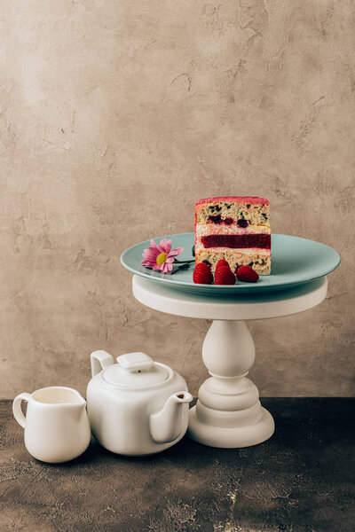 sweet tasty cake with raspberries and flower and kettle with porcelain jug