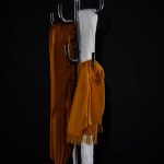 Various scarves hanging on coat rack isolated on black
