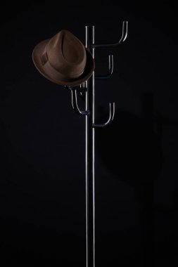classic hat on coat rack isolated on black clipart
