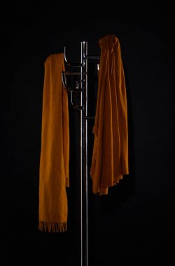 two scarves on coat rack isolated on black clipart
