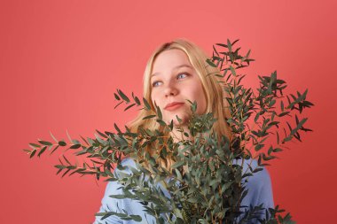 young woman with bunch of eucalyptus branches isolated on red clipart