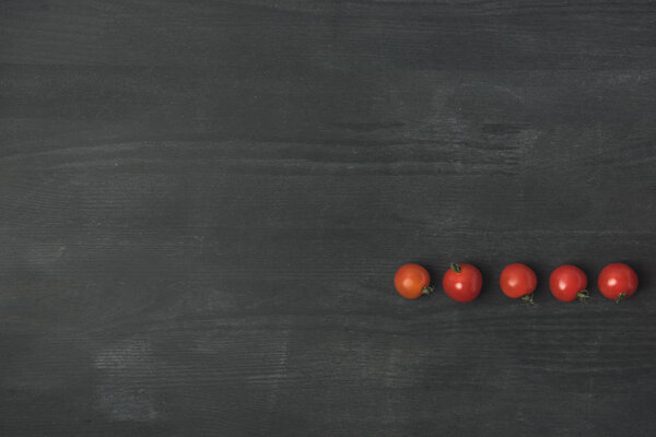 top view of arranged cherry tomatoes on dark grey surface