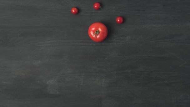 stop motion záběry s čerstvým rajčetem a cherry rajčátky na tmavě šedém povrchu