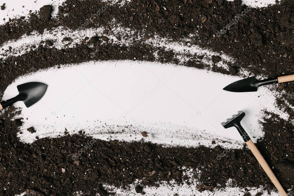 top view of arranged gardening equipment and soil isolated on white