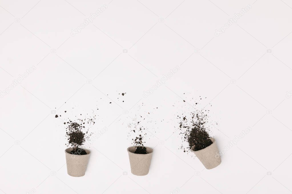 top view of three flowerpots with ground isolated on white