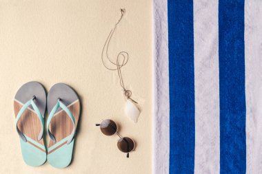 Flip flop ve hafif kum havluda tarafından güneş gözlüğü