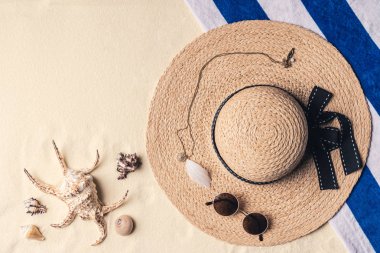 Hasır şapka ile güneş gözlüğü ve deniz kum plajındaki