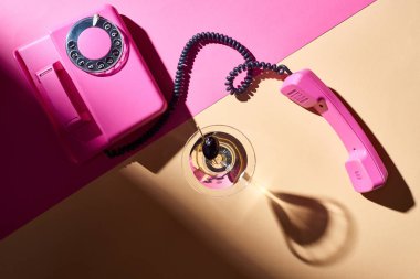 Renkli arka planda retro telefon ve kokteylin üst görünümü