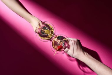 Pembe arka planda kokteyl içen kadın ve erkeğin gölgeli görüntüsü