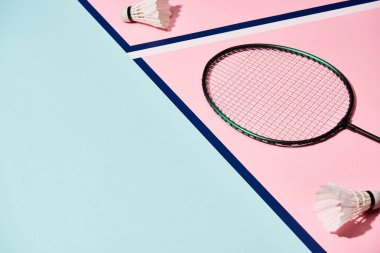 Badminton raketi ve mavi çizgileri olan renkli yüzeyde mekik horozları