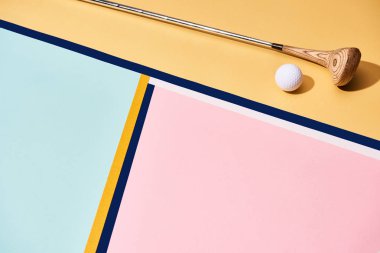 Arka planda renkli çizgileri olan golf sopası ve top