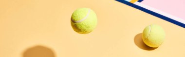 Renkli arka planda gölgeli iki tenis topu, mavi çizgiler, panoramik çekim