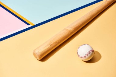 Renkli arka planda ahşap beyzbol sopası ve top