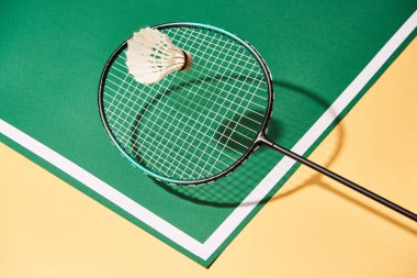 Badminton raketi ve mekik horozu yeşil ve sarı yüzeyde