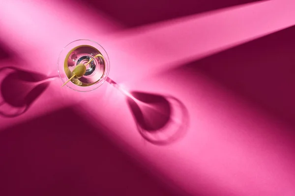 粉色表面有阴影的马提尼鸡尾酒的顶部视图 — 图库照片